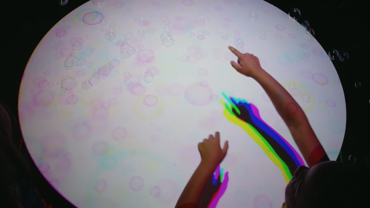 coloridas burbujas de mano niño divirtiéndose jugando con luz multicolor niño jugando con colores del arco iris concepto de la infancia feliz