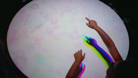 coloridas burbujas de mano niño divirtiéndose jugando con luz multicolor niño jugando con colores del arco iris concepto de la infancia feliz