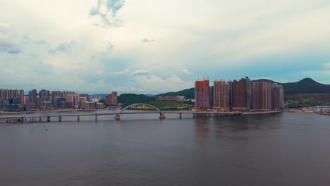 drone wide shot of the tseung kwan o area with lohas park in view and bridge over the water