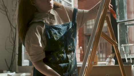 artist adjusting easel indoors