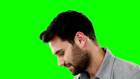 thoughtful man standing against green background