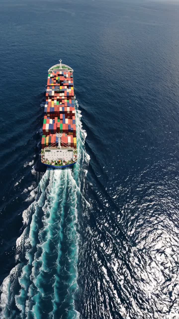 Aerial view of a cargo ship navigating the ocean, showcasing vibrant containers