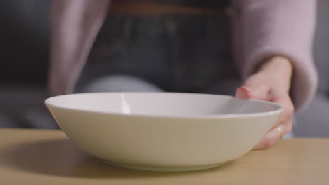 close up de una mujer en casa vertiendo tortilla o papas fritas de maíz de un paquete en un cuenco en la mesa 1