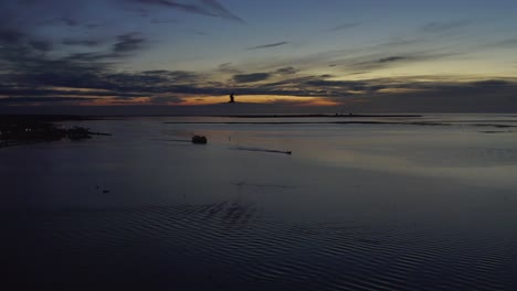 the most gorgeous portuguese sunset off the coast of olhao as seagulls fly and boats travel, drone aerial