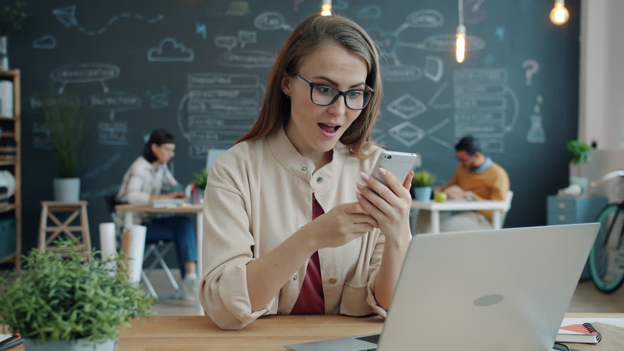 Woman reading on smartphone in office