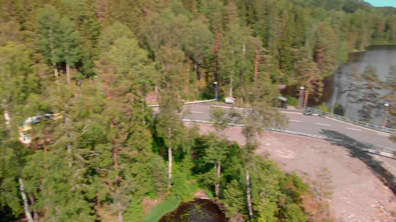 Aerial footage of motorcycle driving on curvy road by the water