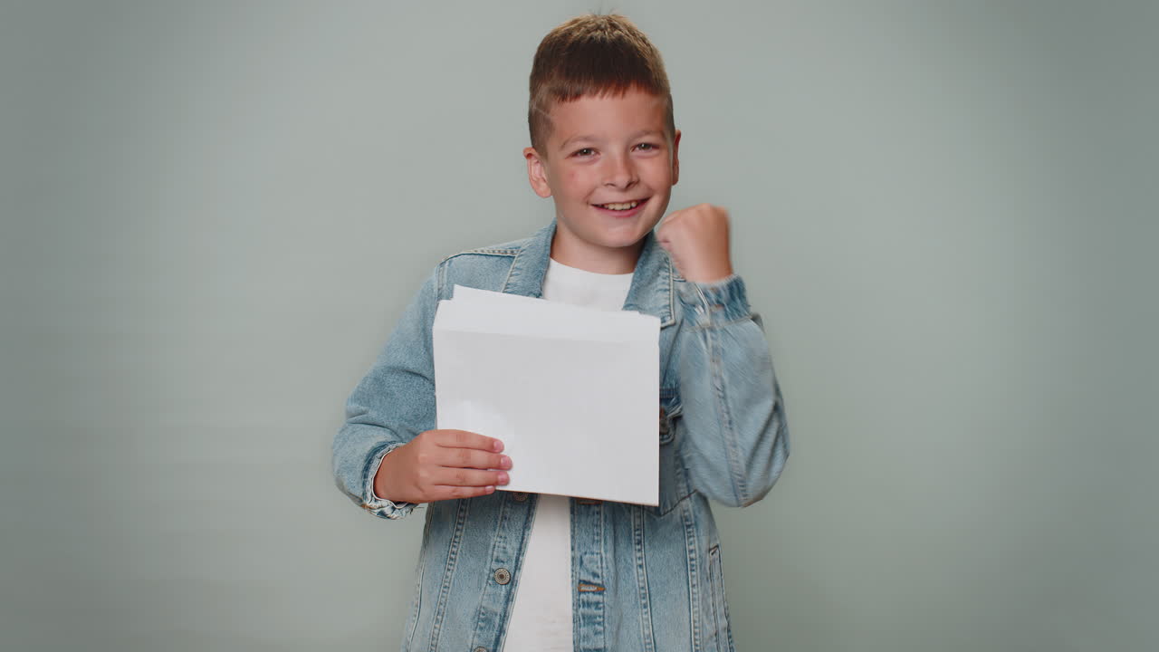 소년은 봉투 편지를 열고 읽습니다. 행복하고, 경력 발전, 승진, 은행 대출 승인