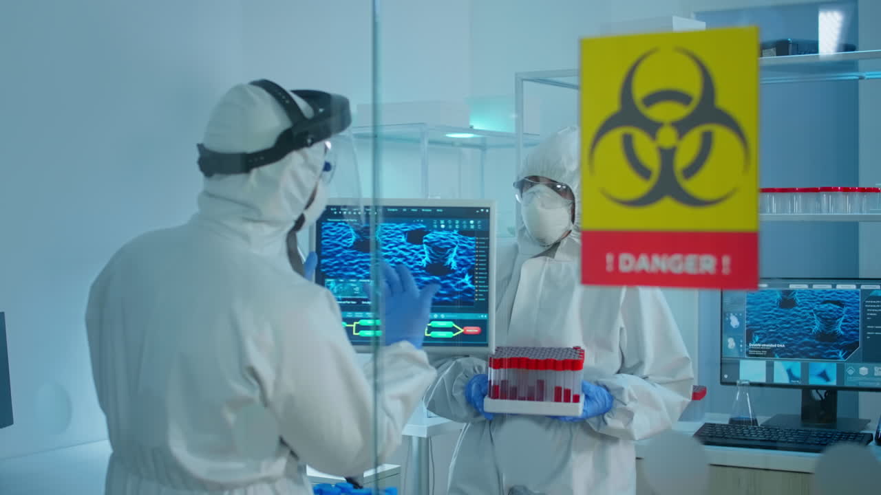 обеспокоенные ученые в костюмах ппэ говорят за стеклянной стеной