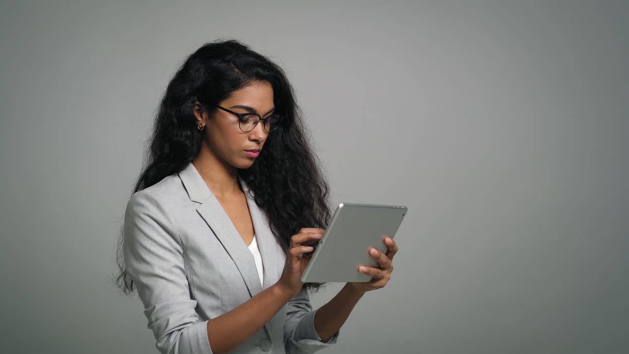 Young African businesswoman uses a digital tablet in studio shot