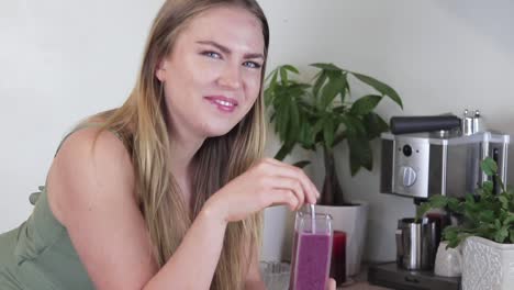 Slow-motion-tight-show-of-girl-blending-a-blueberry-smoothie-in-her-kitchen-with-only-her-hands-showing-in-the-shot