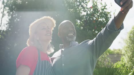 Glückliches-älteres,-Vielfältiges-Paar,-Das-Selfie-Im-Garten-Macht