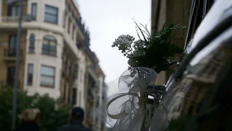 wedding flowers placed on a car blowing in the wind