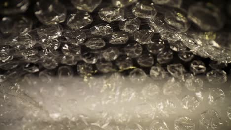 slowly pulling out of the bottom of a bubble wrap bag at first and then speeding towards the opening