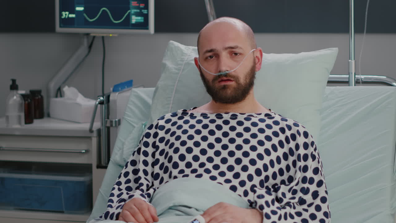 Potrait of hospitalized sick man with nasal oxygen tube having respiratory disorder