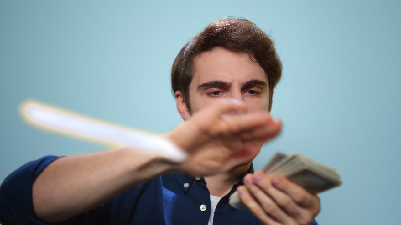 Homem feliz jogando dinheiro. Homem rico segurando dinheiro em fundo azul