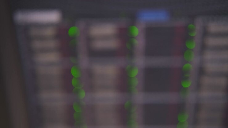 Sfondo sfocato di luci LED di apparecchiature server per telecomunicazioni, primo piano astratto.