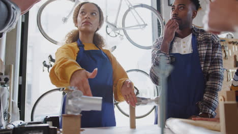 Multi-Cultural-Team-Of-Trainees-In-Workshop-Assembling-Hand-Built-Bicycle-Frame-Together