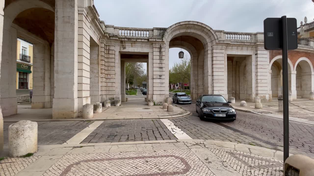 We see the continuous passage of vehicles through a white stone portico that was formerly the Andalusian highway and the church of San Antonio de Padua appears.