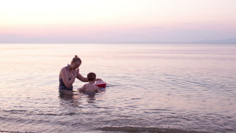 madre jugando con su hijo pequeño con un barco de juguete