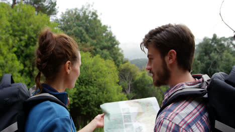 rear view of hikers looking a map with a compass