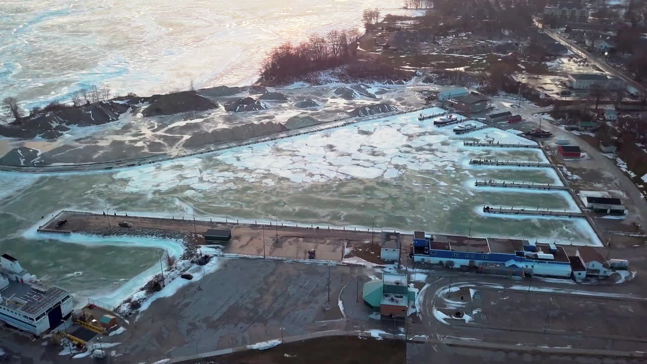 얼어붙은 호수에서 얼음으로 둘러싸인 채석장과 부두를 뒤로 당기면 캐나다 해안선을 따라 아름다운 일몰이 나타납니다.