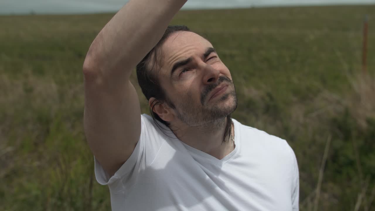 하 셔츠를 입은 남자가 손을 들고 하늘을 향해 손을 고