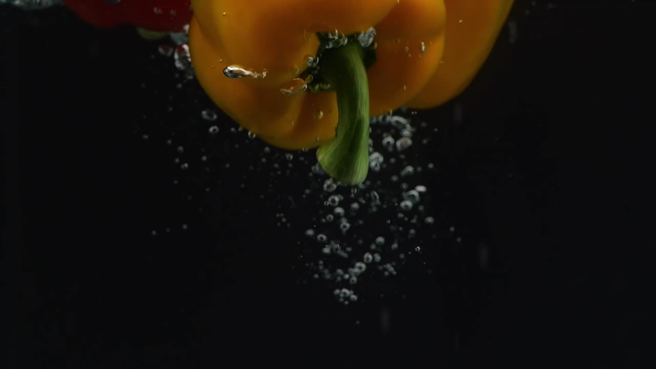 tres papeles de campana cayendo en el agua sobre el fondo negro