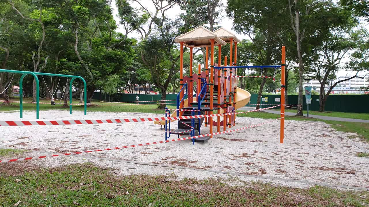 Children's playground with barrier tape and warning signs during Covid-19 lockdown in a public park in Singapore, Asia