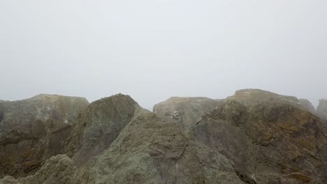 coquille point, bandon oregon coast, fly over rocks to reveal water and fog