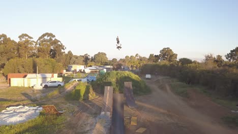 an aerial view of motorcyclists showing off their skills on a springboard