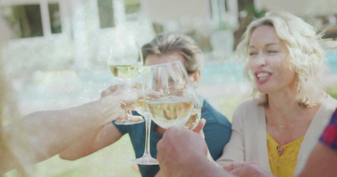 Amici felici che brindano con vino bianco a un raduno all'aperto.