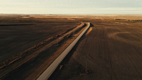 long road through rural fields in mossbank, saskatchewan, canada