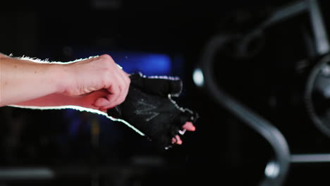 Preparation-For-Training-Woman-Putting-On-Gloves-For-Training-On-A-Dark-Background-In-The-Spotlight