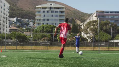 Animation-Von-Social-Media-Symbolen-über-Biracial-Männlichen-Fußballspielern,-Die-Auf-Dem-Sportplatz-Dribbeln