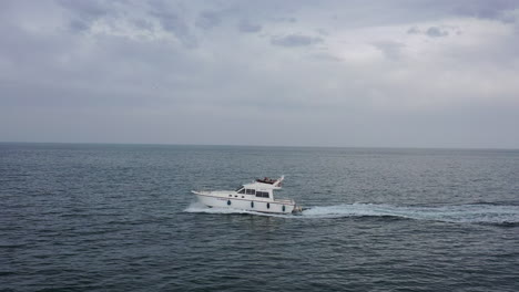 Toma-Aérea-Lateral-De-Un-Barco-De-Recreo-A-Motor-Mar-Mediterráneo-Día-Nublado