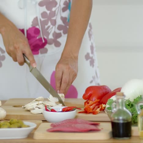 Housewife-preparing-dinner-slicing-fresh-mushrooms