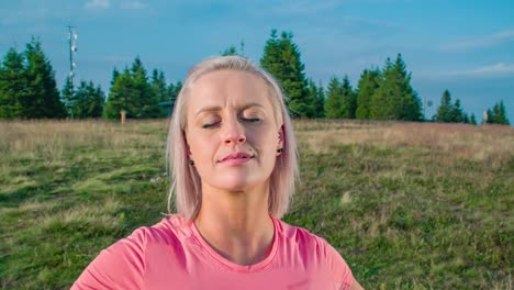 Toma-Orbital-De-Una-Mujer-Joven-De-Pie-Pacíficamente-Con-Los-Ojos-Cerrados-Rodeada-De-Naturaleza