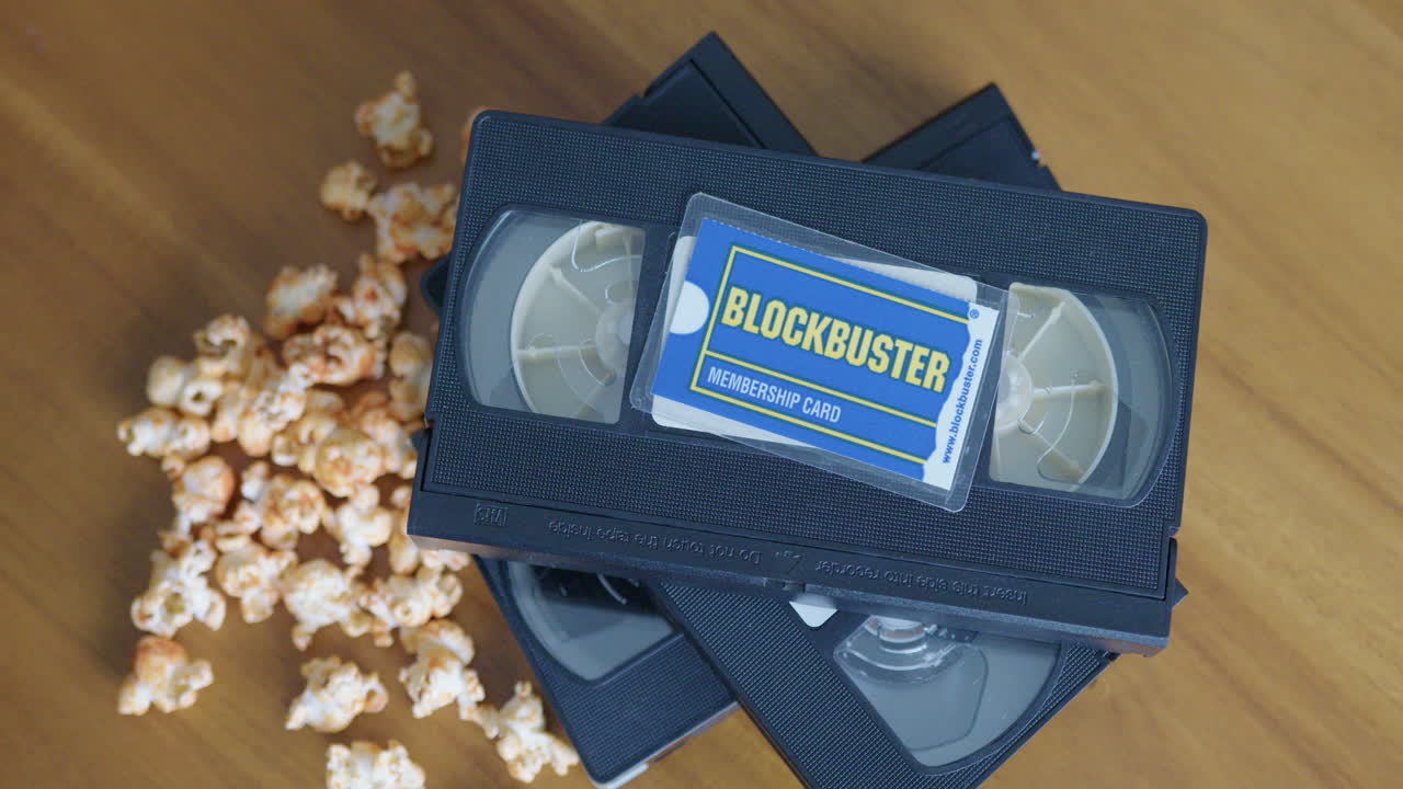 Wide Pan Right Shot of a Blockbuster Membership Card with VHS Tapes and Popcorn