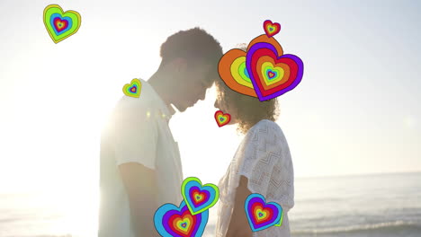 animation of hearts moving over diverse couple in love holding hands on beach in summer