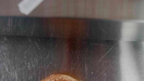 gloved hands separate buns to put together burger in kitchen, close-up