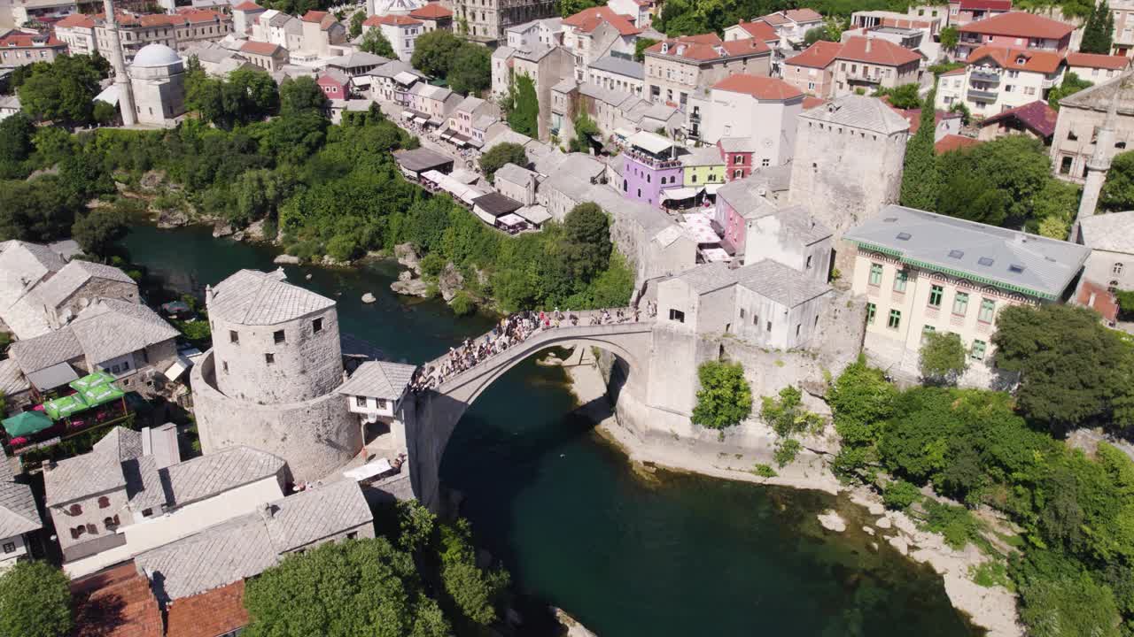 Crowded Stari Most arch bridge over Neretva river in Mostar's heart, Bosnia