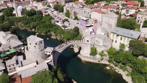 crowded stari most arch bridge over neretva river in mostar's heart, bosnia