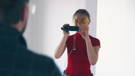 chica alegre con teléfono inteligente dispara a su novio bailando en la habitación