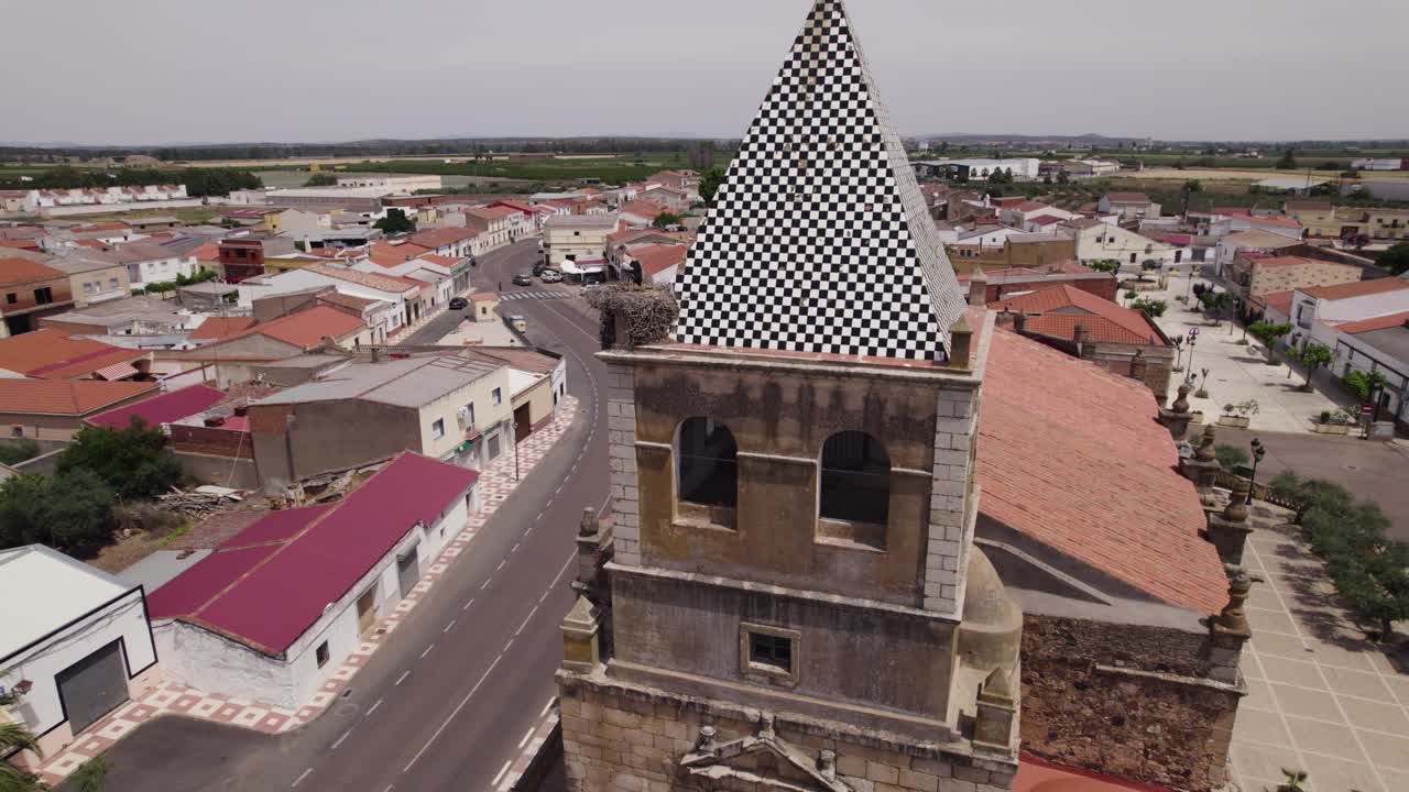 vista aérea de la torre del campanario de la iglesia de torremayor con techo rojo y edificios encalados en la provincia de badajoz