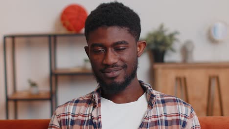 lovely playful happy man african american smiling blinking eye, looking at camera with toothy smile