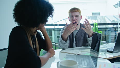 gen z businessman giving papers to colleagues on meeting