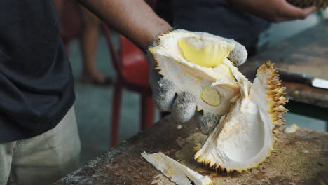 Opening-fresh-ripe-delicious-durian-fruit-outdoor-close-up