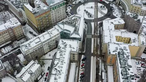 Vista-Aérea-Con-Vistas-A-Los-Tranvías-En-Las-Calles-Nevadas-De-Varsovia,-Invierno-En-Polonia---Aumento,-ángulo-Alto,-Disparo-De-Drones