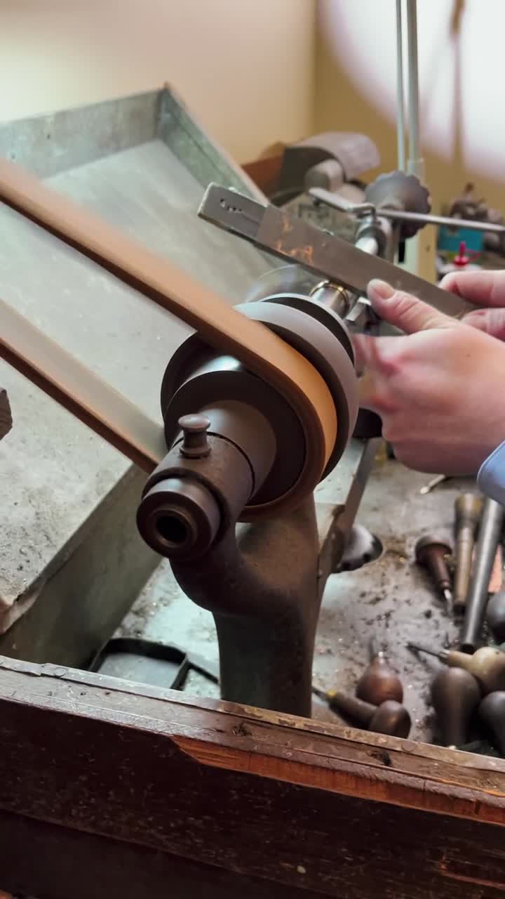 Un gioielliere modella un anello d'oro su un tornio d'epoca.