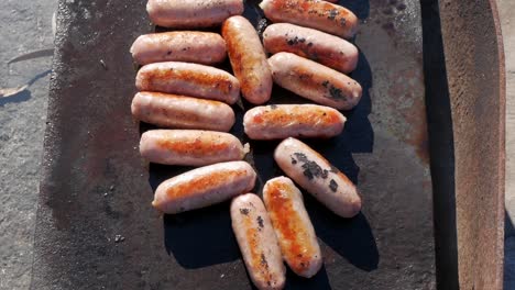 pork sausages cooking on an open fire barbecue